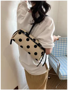Lifestyle-Aufnahme einer trendigen gepunkteten Canvas-Baguette-Tasche auf der Schulter.