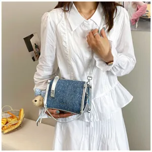 Close-up of blue denim crossbody bag with silver hardware and bear charm detail