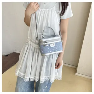 Stylish blue denim box crossbody bag with silver star charms and studs shown on model