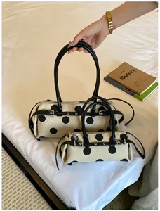 Detailansicht von großen und kleinen Polka Dot Canvas Baguette-Taschen mit Riemen.