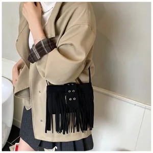 Close-up of black faux suede crossbody bag with vintage fringe and belt buckle