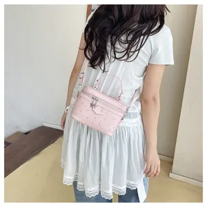 Chic pink box-shaped crossbody bag with star charms and rivet details shown on a model