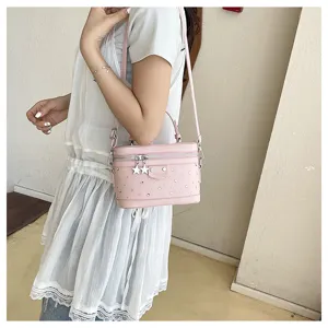 Close-up of elegant pink rhinestone box handbag worn as a crossbody bag with star charms