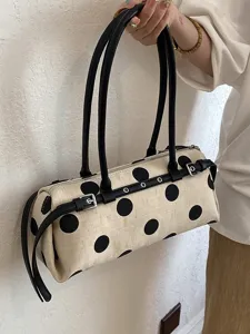 Schicke Polka-Dot Canvas Baguette-Tasche mit schwarzen Schnallen und langen Trägern.