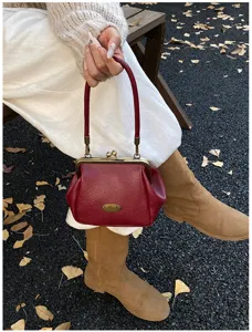 Élégant sac à main rouge vintage en similicuir avec fermoir à baiser pour l'automne chic.