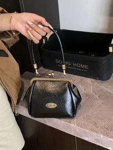 Sac à main vintage noir en forme de coquille avec fermoir rétro et cuir souple premium