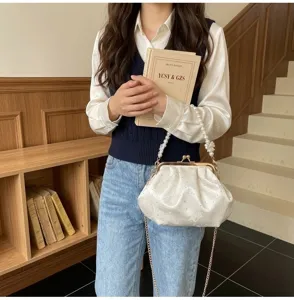 Elegante bolso bordado de concha blanco con asa de perlas y detalles de pedrería fina