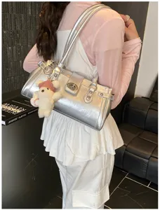 Silberne Baguette-Tasche im Metallic-Look mit Schloss, von einem Modell getragen