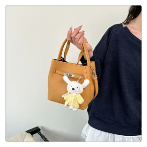 Nahaufnahme der gelben Beuteltasche mit Lychee-Muster, Schloss und süßem Hasen-Anhänger