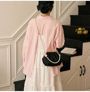 Elegante bolso de fiesta tipo concha negro con asa de perlas y cadena dorada en modelo