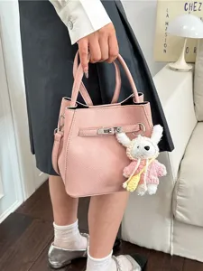 Elegante rosafarbene Eimertasche aus genarbtem Leder mit Metallschloss und Hasenanhänger