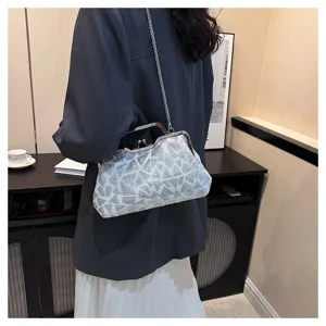Silver sequined evening clutch bag with metal clasp and chain strap worn over blazer