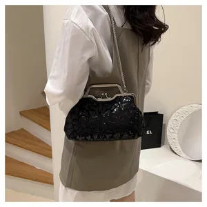 Model wearing a black sequin kiss-lock evening bag with silver chain strap