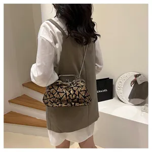 Sequin evening bag with metal clasp and chain strap displayed in a stylish lifestyle setting