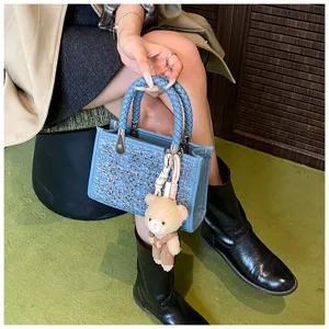 Elegant blue denim sequin tote bag with woven handles and cute bear charm detail