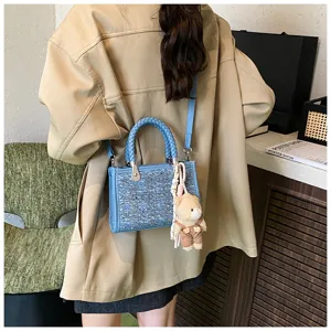 Trendy denim blue woven small tote bag with sequin finish worn as a crossbody bag