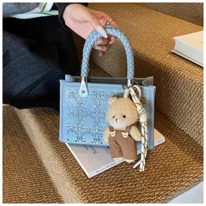 Detailed view of denim blue mini tote bag featuring sequin pattern and cute bear charm
