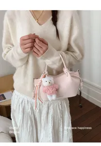 Lifestyle-Ansicht einer rosa gefalteten Beuteltasche mit einem süßen weißen Bärenanhänger