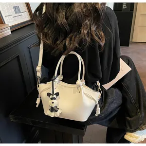 Elegante weiße Mini-Handtasche mit Hundeanhänger in einer stilvollen Lifestyle-Szene