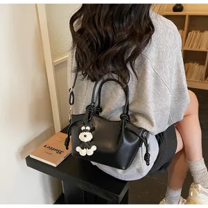 Stilvolle schwarze kleine Bucket-Tasche mit Schnauzer-Hund-Anhänger in Lifestyle-Szene