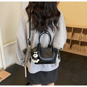 Rückansicht einer minimalistischen schwarzen Beuteltasche mit Hundemotiv-Anhänger