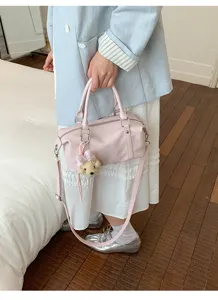 Vue détaillée du sac Boston en cuir souple rose clair avec charmant ours en peluche