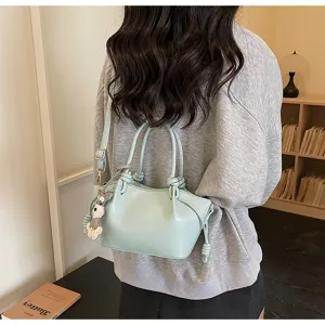 Elegante hellblaue kleine Tragetasche mit Hundianhänger, getragen von einem Modell