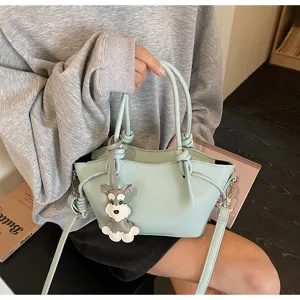 Detailansicht einer mintgrünen Beuteltasche mit Hundeanhänger am Modell