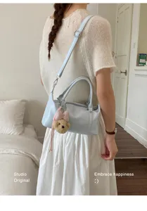 Sac d'oreiller en cuir souple bleu clair avec breloque ours porté par un mannequin