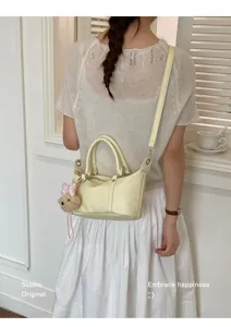 Vue arrière d'un mannequin portant un petit sac Boston jaune en cuir souple