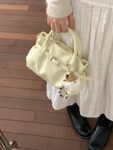 Vintage plissierte blassgelbe Handtasche aus Kunstleder mit Schnalle und flauschigem Anhänger