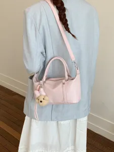 Sac Boston élégant en cuir souple rose avec breloque ours et bandoulière réglable