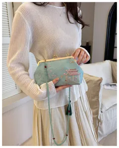 Elegante pochette ricamata azzurra con tracolla di perline e dettaglio nappa verde