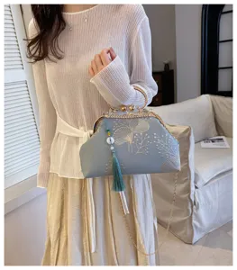 Elegante borsa da sera azzurra con raffinato ricamo floreale e una nappa di seta