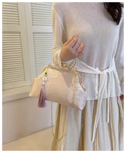 Elegante pochette da sera ricamata beige con chiusura a scatto e nappa.