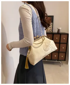 Elegante borsa da sera in seta crema con ricami dorati, chiusura con strass e dettaglio nappa