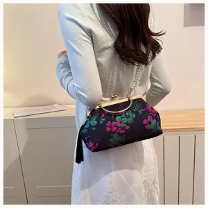 Detailansicht einer bestickten Blumen-Abendtasche mit Perlenriemen und Quaste