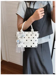 Nahaufnahme einer weißen koreanischen Tasche mit schwarzen Punkten und eleganter Spitzenschleife.
