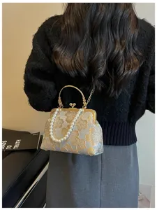 Elegant floral embroidered shell clutch bag with pearl handle and chain strap.