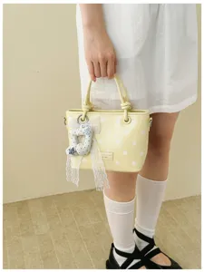 Detailansicht einer gelben Polka-Dot-Beuteltasche im koreanischen Stil mit Spitzenschleife