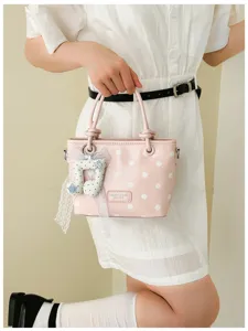 Elegante rosa gepunktete Eimertasche mit Musiknoten-Anhänger und schicker Spitzenschleife