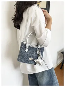 Sac seau en jean élégant avec bordure argentée et breloque étoile sur un mannequin