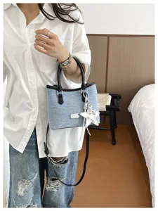 Vue détaillée d'un sac seau en denim bleu clair de style coréen avec pendentif en étoile.