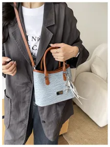 Détail d'un sac seau en denim de style coréen avec poignées en cuir sur modèle