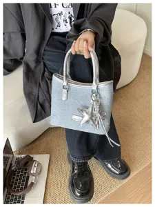 Gros plan d'un sac seau en denim bleu élégant avec un pendentif en forme d'étoile