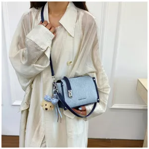 Korean style denim blue crossbody bag with plush puppy charm worn over shoulder