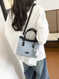 Sac cabas élégant en denim bleu clair porté par un mannequin en intérieur