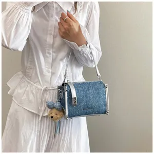 Stylish denim blue bucket shoulder bag with silver trim and cute teddy bear charm