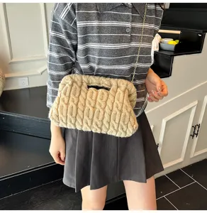 Gedetailleerd overzicht van een beige grof gebreide clutch met een gouden ketting