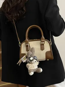 Minimalist two-tone crossbody pillow bag with cute plush rabbit charm accessory